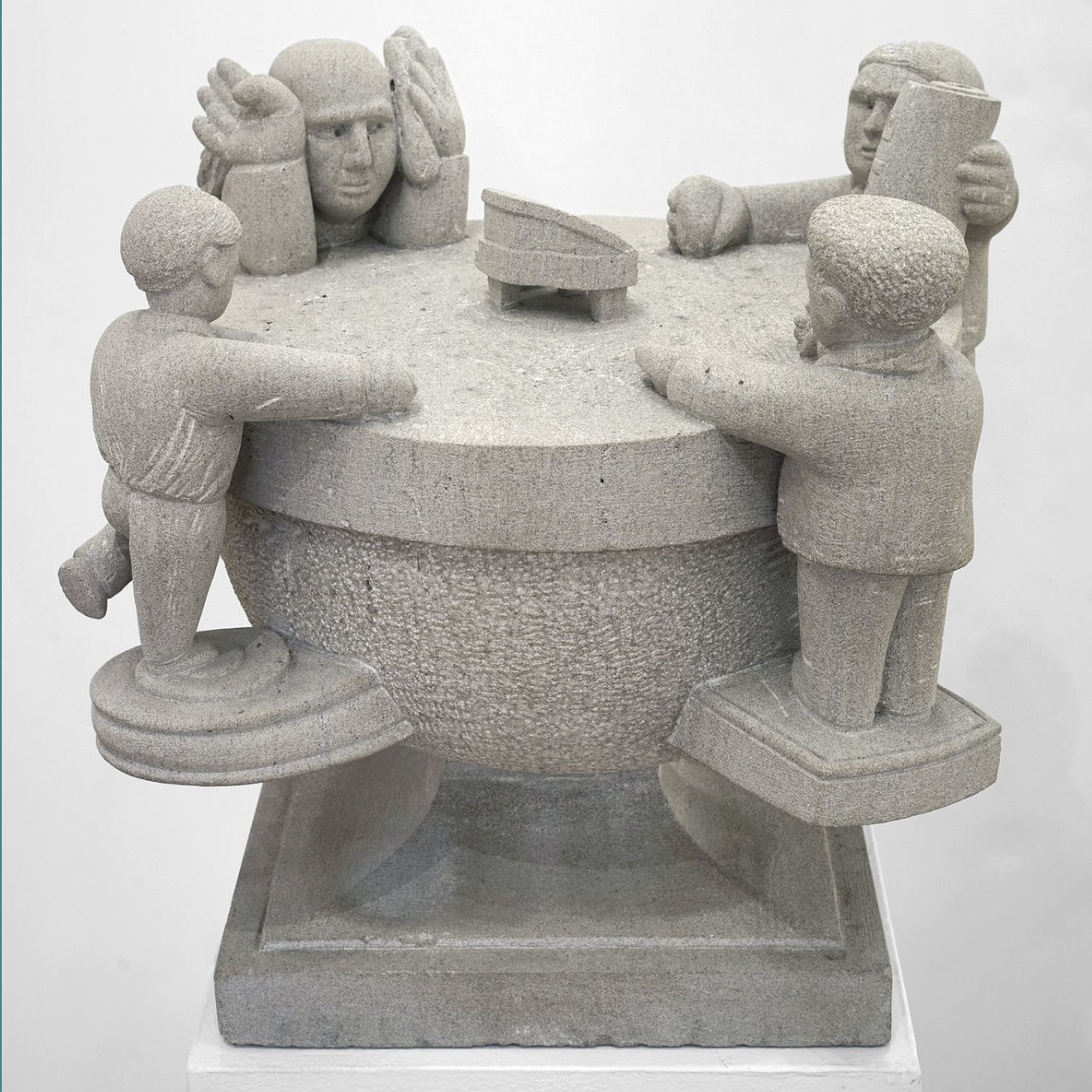 A round half-circle with a flat top and a square base. Around the circumference are four figures, each standing on a ledge that comes off the rounded semicircle. Two figures have their arms resting flat on the top. One has its hands up at the side of its face. The fourth figure is holding up a piece of paper with the text “YTTE” on it, honoring artist Achilles G. Rizzoli. YTTE, the name of his imaginary world, stands for “Yield to Total Elation.”