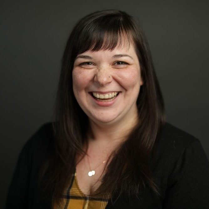 Dani Rose A head shot of Dani Rose, a white female with shoulder length brown hair and bangs smiling at the camera