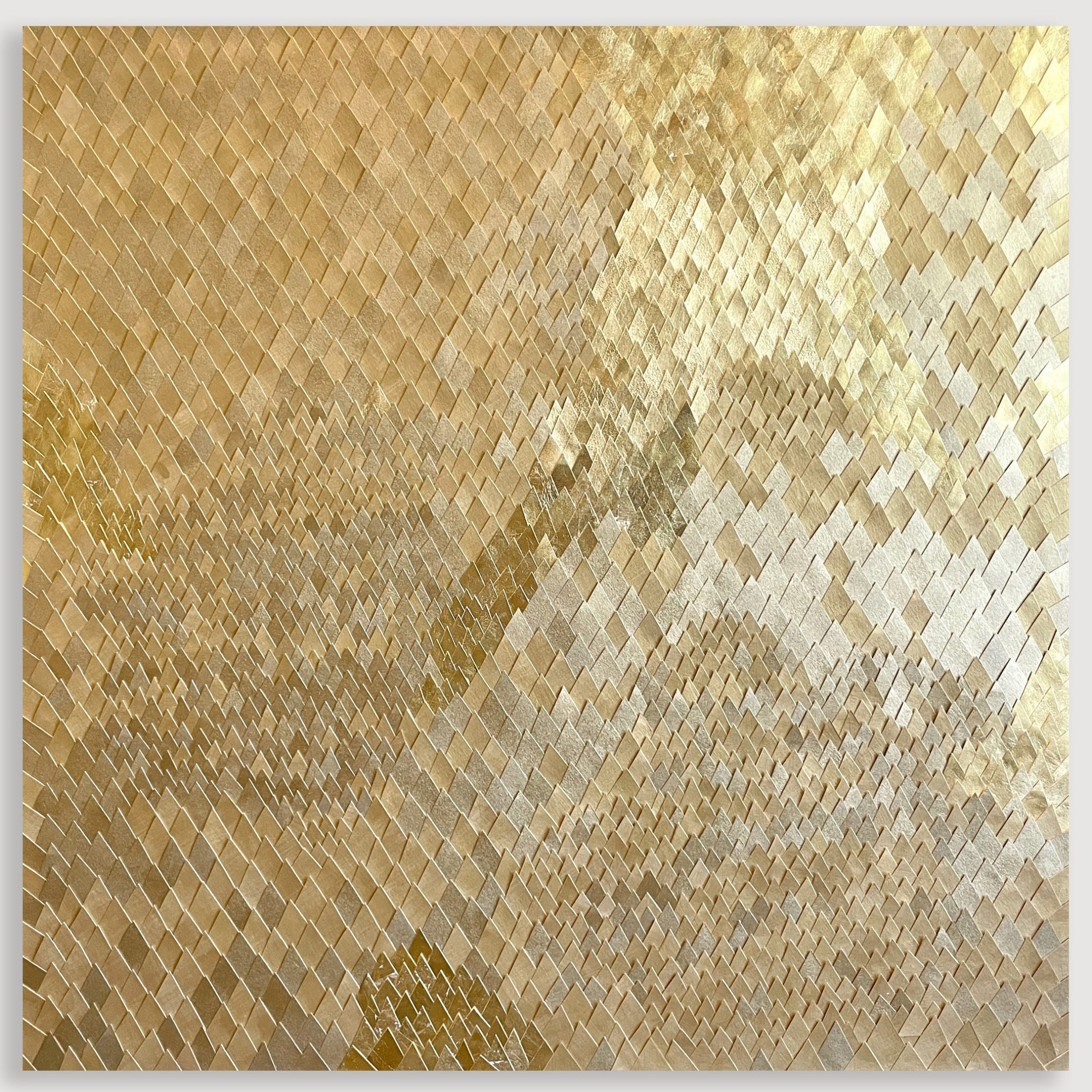 A large square canvas collaged with delicate and detailed diamond shapes made of cut paper that has gold spray paint or gold leaf affixed to them. They create a shimmery repetitive surface.